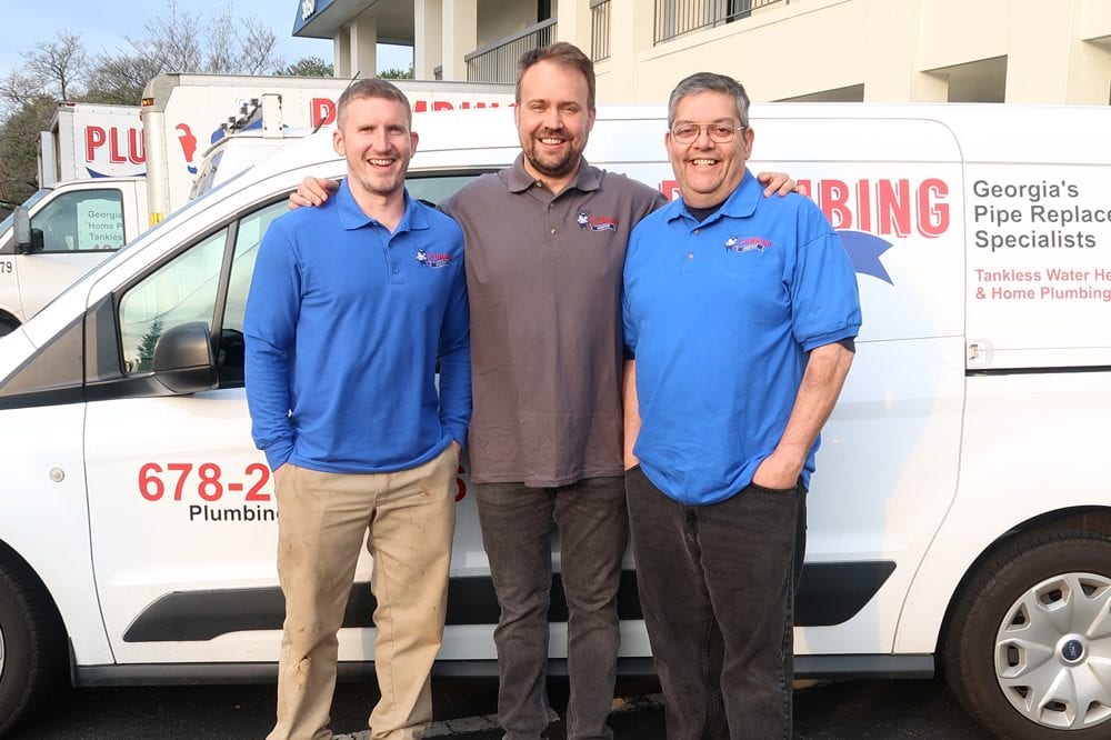 three-employees-posing-in-front-of-company-van-as-a-close-team